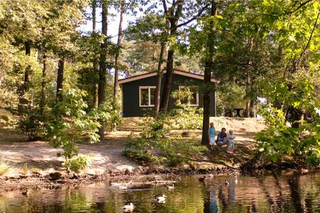 Mensen aan het water bij een chalet op vakantiepark Roompot Bospark 't Wolfsven