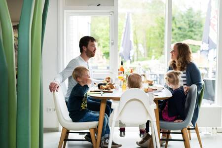 Gezin aan het dineren in het restaurant van Roompot Bungalowpark Hoenderloo