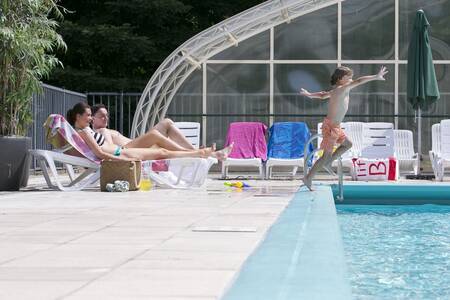 Mensen in het zwembad met een wegschuifbaar dak op Roompot Bungalowpark Hoenderloo