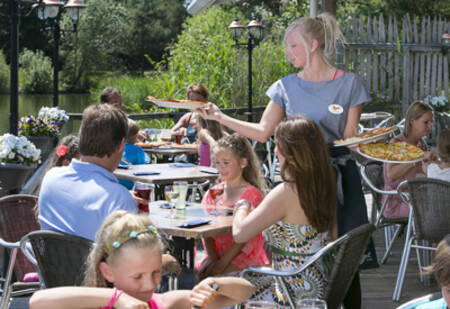 Mensen op het terras van het eetcafé op vakantiepark Roompot Cape Helius