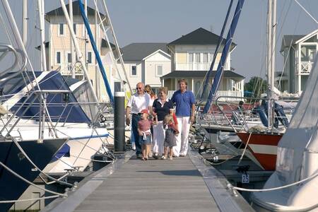 Mensen lopen op een steiger in de jachthaven op vakantiepark Roompot Cape Helius