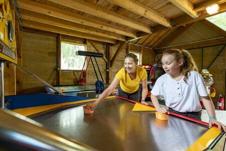 Moeder en dochter spelen airhockey op vakantiepark Roompot Château des Marais