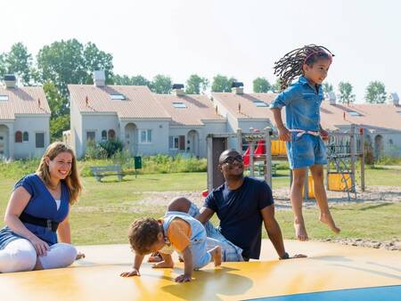 kinderen springen op de airtrampoline in een speeltuin op vakantiepark Roompot Duinresort Dunimar