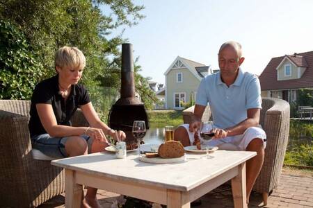 Mensen aan het barbecueën bij een vakantiehuis op Roompot Duynparc De Heeren van ‘s-Gravensande