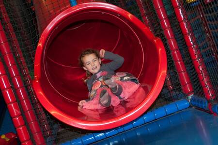 Kind op een glijbaan in de indoor speeltuin op Roompot Ferienresort Cochem