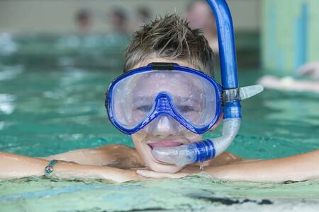 Jongen met duikbril en snorkel in het zwembad van Roompot Ferienresort Cochem