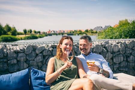 Man en vrouw genieten van een drankje op het terras op Roompot Noordzee Résidence Cadzand-Bad