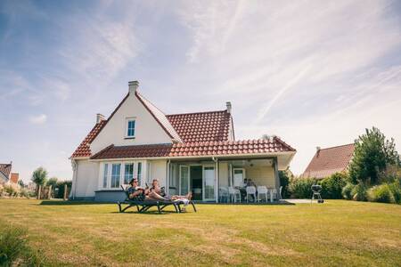 2 mensen in de tuin van een vrijstaande vakantiewoning op Roompot Noordzee Résidence Cadzand-Bad