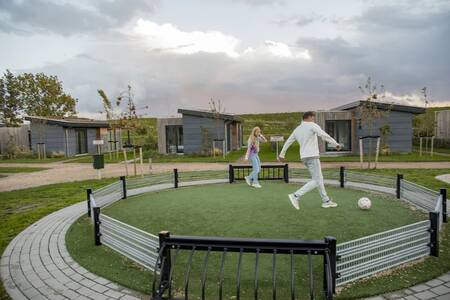 Mensen voetballen in de pannakooi op vakantiepark Roompot Park Wijdenes