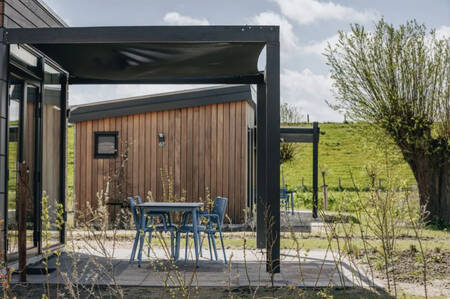 Terras met schaduwdoek van een vakantiehuis op vakantiepark Roompot Park Wijdenes