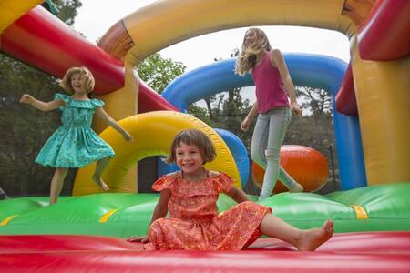 Kinderen springen op het springkussen op vakantiepark Roompot Plein Air des Chênes