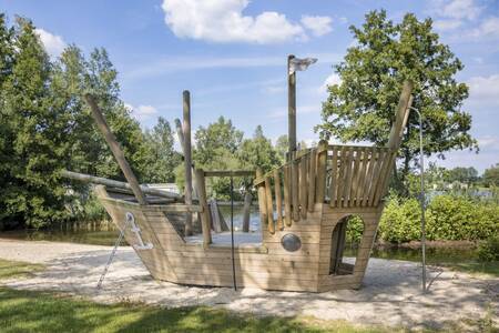 Een speelschip van hout in een speeltuin op vakantiepark Roompot Recreatiepark de Tolplas