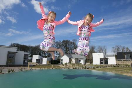 kinderen springen op de airtrampoline in een speeltuin op Roompot Strandpark Duynhille