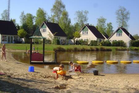 Kinderen spelen op het strand van een recreatiemeer op Roompot Vakantiepark Hellendoorn
