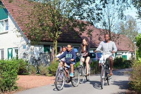Gezin fietst voor vakantiehuizen op Roompot Vakantiepark Hellendoorn