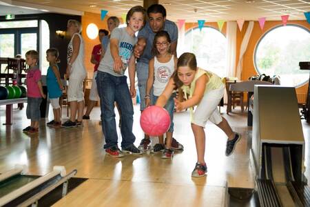 Gezin is aan het bowlen op de bowlingbaan van Roompot Vakantiepark Hunzedal