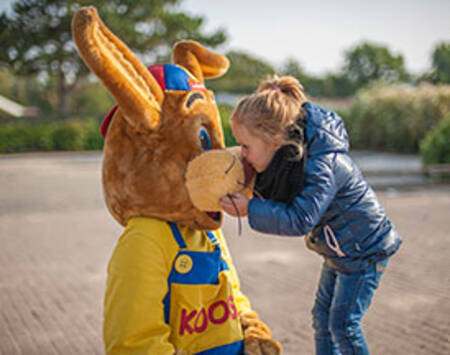 Meisje geeft Koos konijn een knuffel op Roompot Vakantiepark Hunzedal
