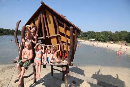 Kinderen op een speeltoestel op het strand op Roompot Vakantiepark Hunzedal