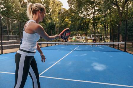 Man en vrouw zijn aan het tennissen op de tennisbaan van Roompot Vakantiepark Kijkduin