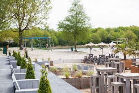 Terras en speeltuin aan de recreatieplas naast Roompot Villaparc Schoonhovenseland