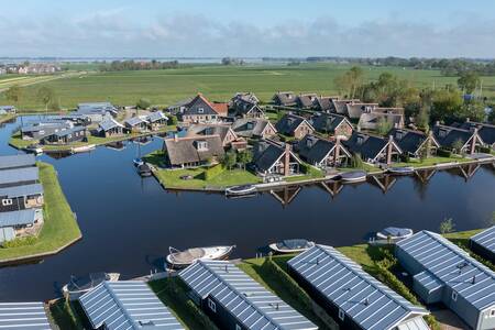 Luchtfoto van vakantiehuizen aan het water op vakantiepark Roompot Waterpark Terkaple