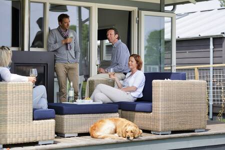 Mensen in de tuin op een loungeset bij een vakantiehuis op vakantiepark Roompot Waterpark Terkaple