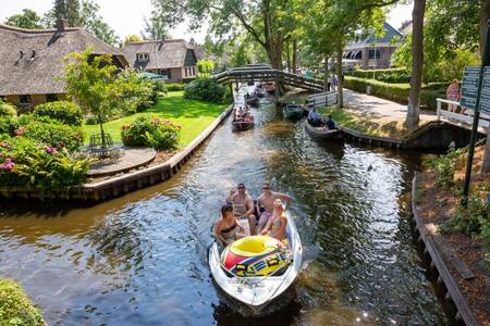 Mensen varen door Giethoorn nabij vakantiepark Roompot Waterstaete Ossenzijl