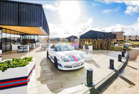 Buiten het restaurant van Roompot Zandvoort staat een Porsche