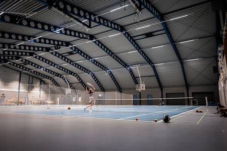 Mensen aan het tennissen op de indoor tennisbaan van vakantiepark Roompot Zeebad