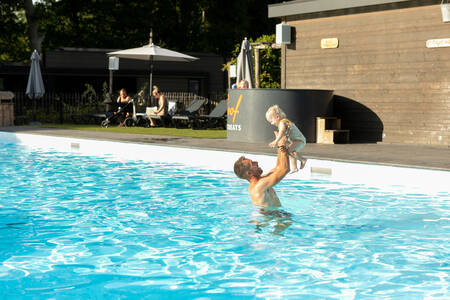 Vader met kind in het buitenbad op vakantiepark Soof Retreats Soof Heuvelrug