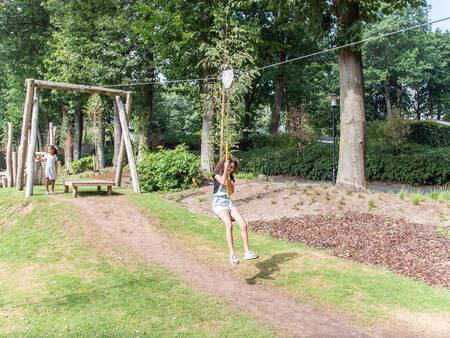 Meisje op de kabelbaan in een speeltuin op vakantiepark Topparken Landgoed de Scheleberg