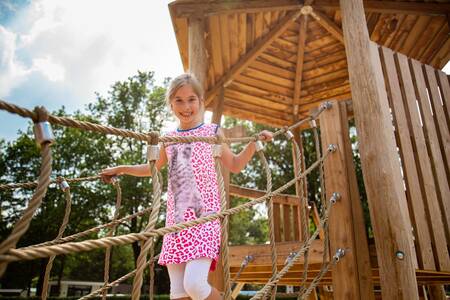 Meisje speelt op een speeltoestel in een speeltuin op vakantiepark Topparken Parc de IJsselhoeve