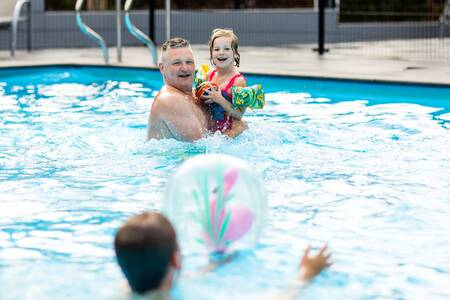 Gezin aan het zwemmen in het buitenbad van vakantiepark Topparken Recreatiepark Beekbergen