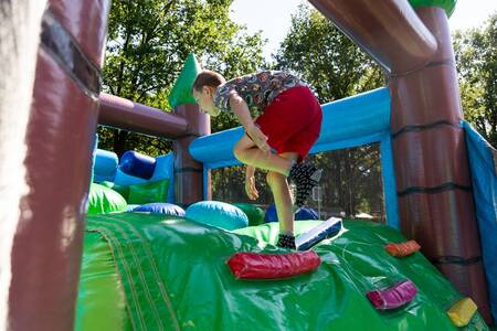 Een jongen klimt op een klimkussen op vakantiepark Topparken Recreatiepark 't Gelloo