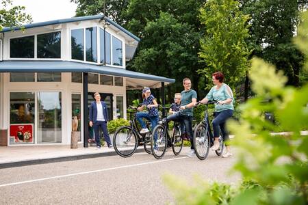 Mensen op fietsen bij de receptie van vakantiepark Topparken Recreatiepark 't Gelloo