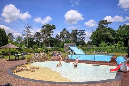 Kinderen zwemmen in het peuterbad buiten op vakantiepark Topparken Resort Veluwe