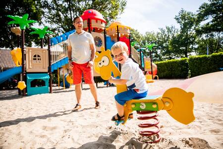 Kind op een wipkip in een speeltuin van vakantiepark Topparken Résidence De Leuvert