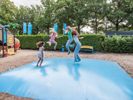 Kinderen springen op een airtrampoline in een speeltuin op Topparken Résidence De Leuvert