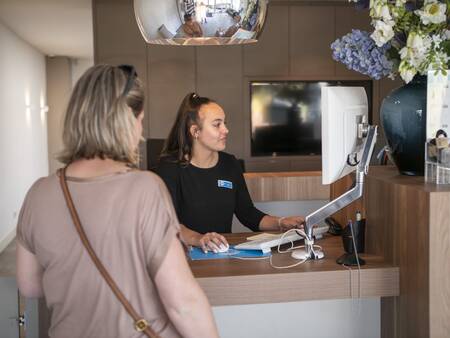 Vrouw bij de receptie van vakantiepark Topparken Résidence Valkenburg