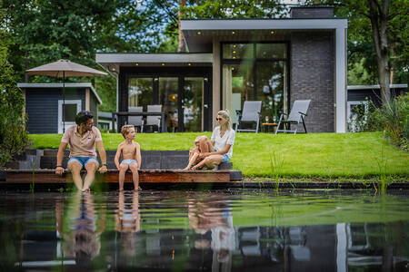 Gezin op een steiger bij een vakantiehuis op vakantiepark De Rimboe en De Woeste Hoogte