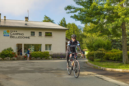 Man fietst voor de receptie van vakantiepark RCN Belledonne