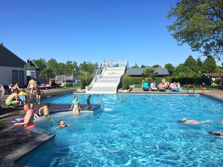 Mensen aan het zwemmen in het buitenbad van vakantiepark 't Rheezerwold