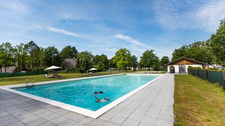 Mensen zwemmen in het buitenbad van vakantiepark Villapark Hof van Salland